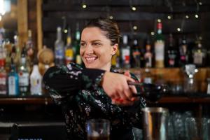 una mujer sentada en un bar sirviendo una bebida en Chapter House, en Salisbury