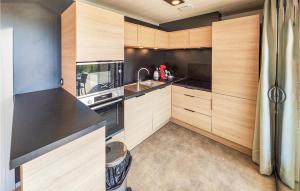 kuchnia z drewnianymi szafkami i czarnym blatem w obiekcie Gorgeous Home In Olonzac With Kitchen w mieście Olonzac