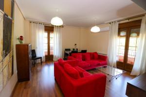 a living room with a red couch and a table at Apartamentos El Retiro del Mirador by RetiroRural in Arenas de San Pedro