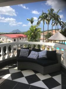 聖呂斯的住宿－Villa Beauregard，棕榈树阳台的沙发