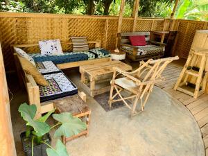 d'une terrasse avec un canapé, des chaises et une table. dans l'établissement Mambo & Jambo House, à Mwanza