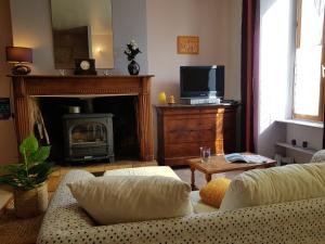 a living room with a couch and a fireplace at La Maison de Simon jusqu'à 8, 3 étoiles, à partir de 16 euros la nuit par personne in Laparade