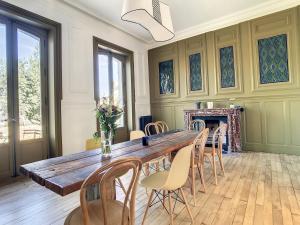 uma sala de jantar com uma grande mesa de madeira e cadeiras em Maison Lacase em Saint Malo