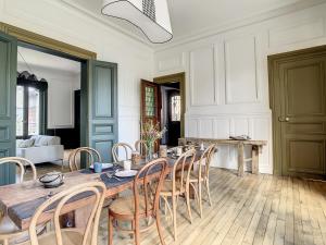 uma sala de jantar com uma mesa de madeira e cadeiras em Maison Lacase em Saint Malo