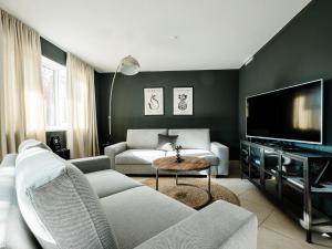 een woonkamer met een bank en een tv bij Ferienwohnung Auszeit in Chieming