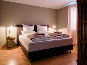 een slaapkamer met een groot bed met witte lakens en kussens bij Ferienwohnung Auszeit in Chieming