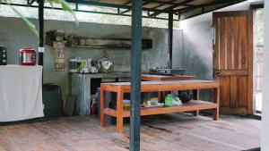 Zimmer mit einem Holztisch und einer Theke. in der Unterkunft Lullabi Lumbung Villa in Lajor