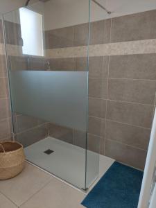La salle de bains est pourvue d'une douche avec une porte en verre. dans l'établissement Magnifique suite familiale, à Nans-les-Pins