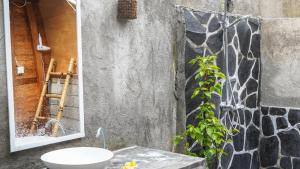 ein Badezimmer mit einem Waschbecken und einem Spiegel an der Wand in der Unterkunft Lullabi Lumbung Villa in Lajor + 28 Fotos