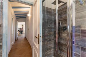 uma cabina de duche ao nível do chão com uma porta de vidro no corredor em Statzu Butzu em Costa Paradiso