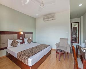 Schlafzimmer mit einem Bett, einem Schreibtisch und einem Stuhl in der Unterkunft Hotel Royal Palm - A Budget Hotel in Udaipur in Udaipur