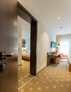 una habitación de hotel con una puerta que conduce a un dormitorio en Landhaus Biewald en Gotinga