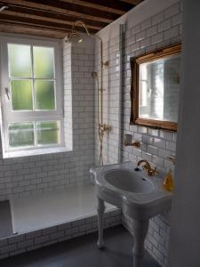 baño blanco con lavabo y ventana en Gamotel, en Vitteaux