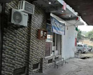 un edificio de ladrillo con un banco delante de él en Vedanta Hotel, Bareilly, en Bareilly