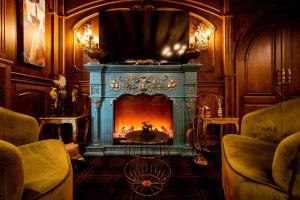a living room with a blue fireplace with a fire at Casa Timiș - Wellness & Spa Resort in Chiţorani