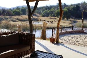 een patio met een bank en uitzicht op een rivier bij Waterberg Game Lodge in Bela-Bela