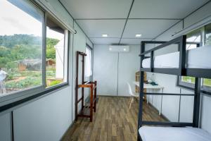a dorm room with bunk beds and a desk at Cozy Farm Stay in Matale