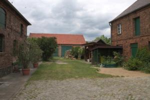 a yard between two brick buildings with a house at Spreewälder Schwalbenhof - Ferienwohnung "Nistkasten" in Golßen