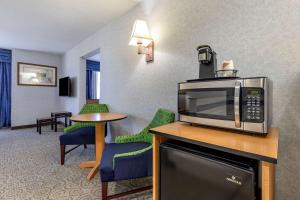 a hotel room with a microwave and a table and chairs at Quality Inn and Suites Denver Airport - Gateway Park in Aurora