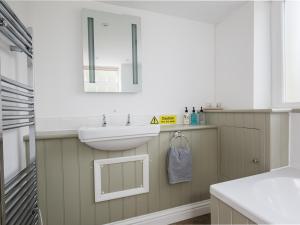 a bathroom with a sink and a mirror at Queens in Winchcombe