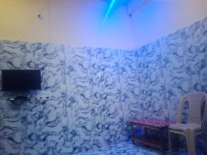 Habitación con pared blanca, mesa y TV. en Indian Family Lodge, Rajnandgaon, Chhattisgarh en Dongargarh