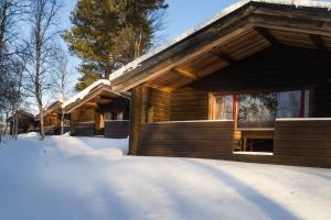 a log cabin with snow in front of it at Lullens Stugby - Stugorna 1-5 in Bruksvallarna
