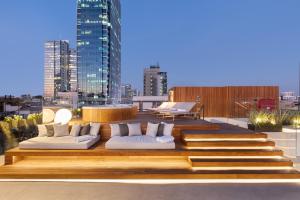 un patio en la azotea con sofás blancos en un edificio en The Levee, en Tel Aviv