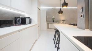 a kitchen with white cabinets and a counter with a microwave at Apartamento Deluxe cerca de la Catedral by Toledo AP in Toledo