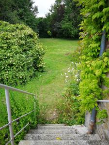 eine Treppe, die zu einem Hof mit einem Zaun führt in der Unterkunft La Folia - Ferme de Lucqy 