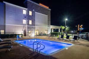 Comfort Inn & Suites Victoria North في فيكتوريا: مسبح امام مبنى في الليل