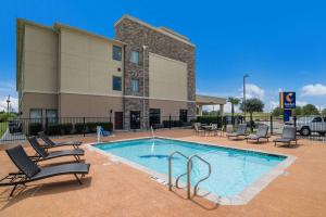 una piscina con tumbonas y un edificio en Comfort Inn & Suites Victoria North, en Victoria