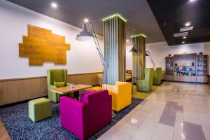 una sala de espera con sillas coloridas y una mesa en Park Inn by Radisson, Kigali en Kigali