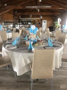 długi stół z ustawieniami niebiesko-białych w obiekcie COMPLEX AGREMENT BELLAVI w mieście Ocna Mureş