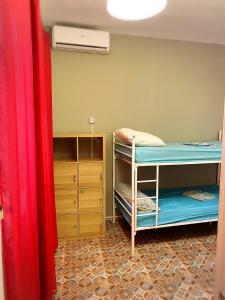 een kamer met 2 stapelbedden en een dressoir bij Cathedral Malaga Hostel in Málaga