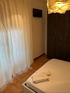 a bedroom with a bed with two towels on it at Nic holiday house in Santa Marinella +8 photos