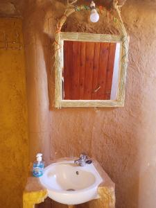 a bathroom with a sink and a mirror at SaharaTime Camp in Hassilabied