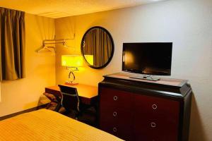a bedroom with a bed and a desk with a television at Super 8 by Wyndham Benton Harbor St Joseph in Benton Harbor