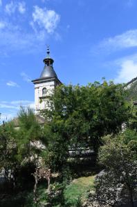 um edifício com uma torre de relógio numa colina em Hôtel de Ville d'Ollon em Ollon