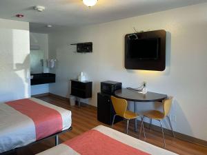 Habitación de hotel con cama, mesa y TV. en Motel 6 Cameron MO, en Cameron