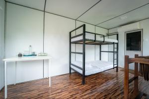 a room with two bunk beds and a desk at Cozy Farm Stay in Matale