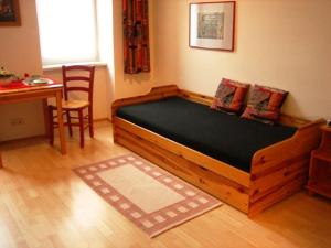 a bedroom with a wooden bed with a table and a chair at Apartment Haydnpark in Vienna