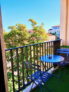 einen blauen Tisch und Stühle auf dem Balkon in der Unterkunft Le Point Virgule - Parking Privé - Climatisation in Montauban
