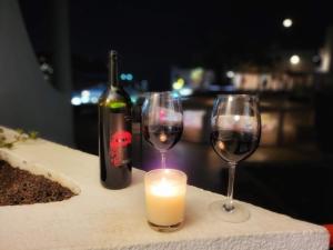 dwa kieliszki wina i świeczka na stole w obiekcie Holidays in Paradise w mieście Mogán
