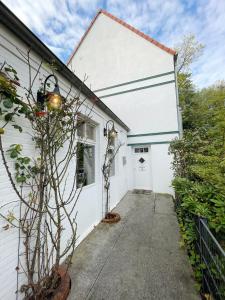 a white house with a door and a driveway at Hotel Xenia Flensburg in Flensburg