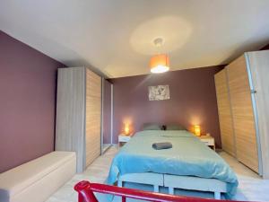 a bedroom with a bed and a couch in it at Agréable maison de ville avec parking gratuit in Corent