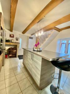 a large kitchen with a counter and a staircase at Agréable maison de ville avec parking gratuit in Corent