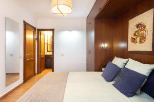 Un dormitorio con una cama grande con almohadas azules. en Icod de los Vinos Centro, en Icod de los Vinos