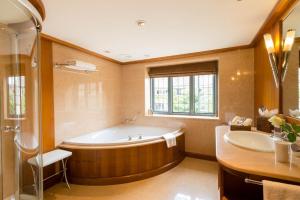 a large bathroom with a tub and a sink at Whatley Manor in Malmesbury