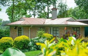 una pequeña casa de ladrillo con techo de estaño en Zoe Homes 1br and 2br Cottage own compound -Kericho town near Green Square mall, en Kericho
