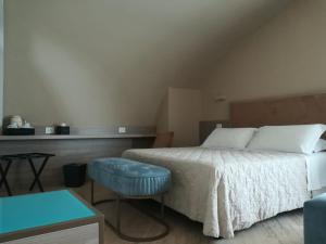 a bedroom with a bed with a blue stool next to it at EUROPA Hotel in Vasto